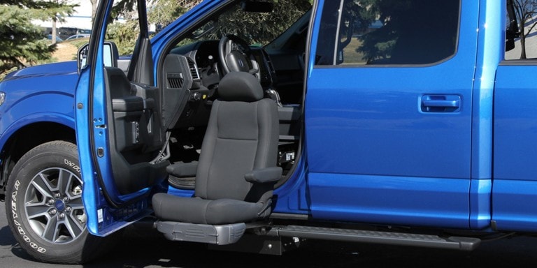 Power assisted seat coming out from the driver side of a pickup truck.